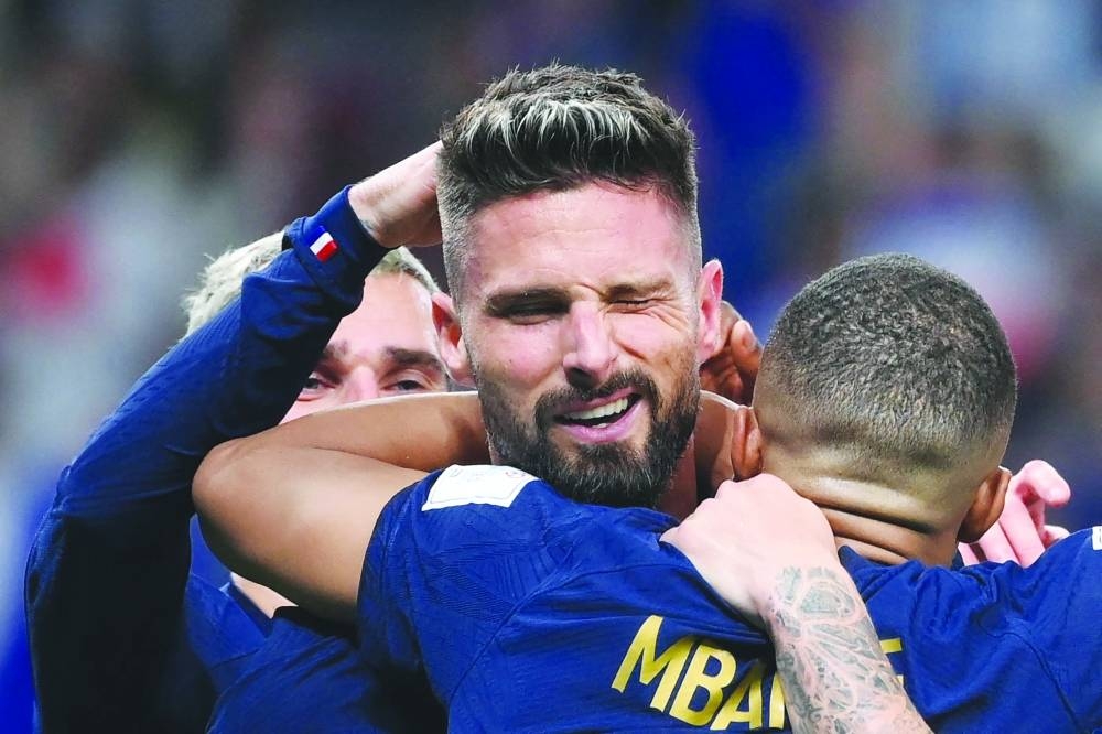 France's forward Olivier Giroud celebrates with teammates after he scored during the Qatar 2022 World Cup Group D football match between France and Australia at the Al-Janoub Stadium in Al-Wakra.