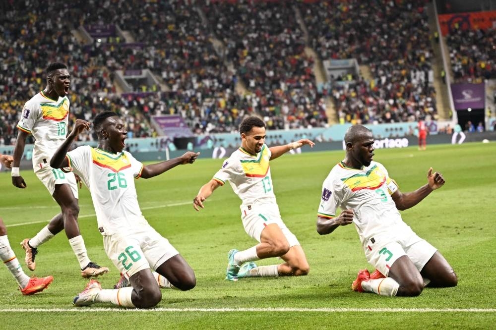 Senegal's defender Kalidou Koulibaly (R) celebrates scoring his team's second goal during the Group A match between Ecuador and Senegal at the Khalifa International Stadium in Doha