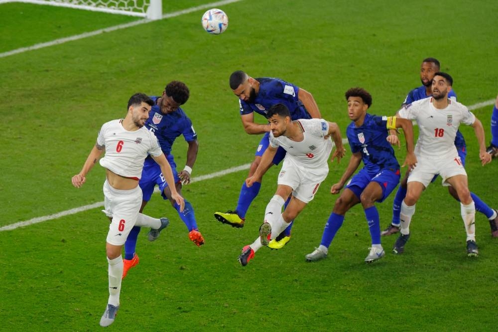 USA's midfielder Yunus Musah fights for the ball with Iran's midfielder Saeid Ezatolahi during the Group B football match between Iran and USA at the Al-Thumama Stadium