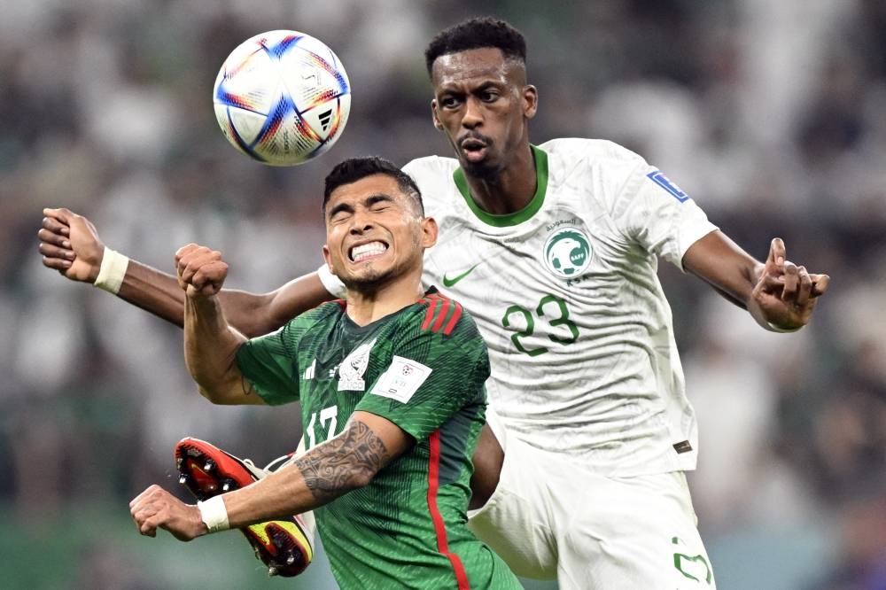 Mexico's goalkeeper Rodolfo Cota (L) fights for the ball with Saudi Arabia's midfielder Mohamed Kanno (R) during the Qatar 2022 World Cup Group C football match at the Lusail Stadium Wednesday.