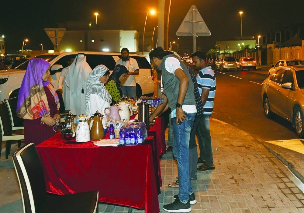 Fans receive refreshments outside a Qatari house near Al Thumama Stadium.