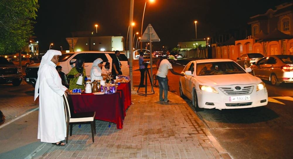 Fans leaving Al Thumama Stadium are offered refreshments by a Qatari household