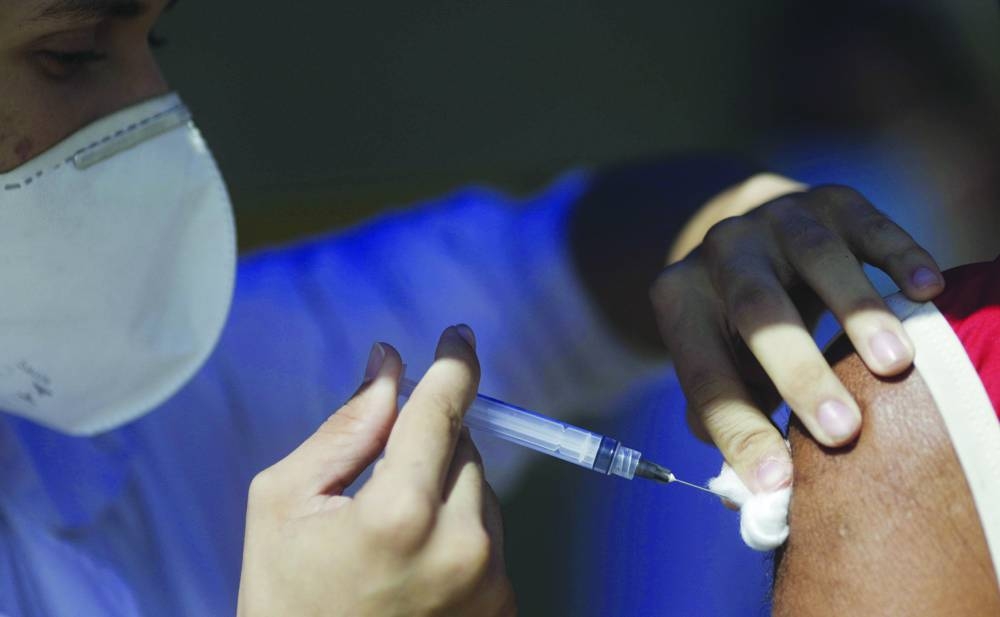 FILE PHOTO: A citizen receives a dose of the AstraZeneca coronavirus disease (COVID-19) vaccine, during a vaccination day for 57-year-old and older citizens, in Duque de Caxias near Rio de Janeiro, Brazil April 21, 2021. REUTERS/Ricardo Moraes/File Photo