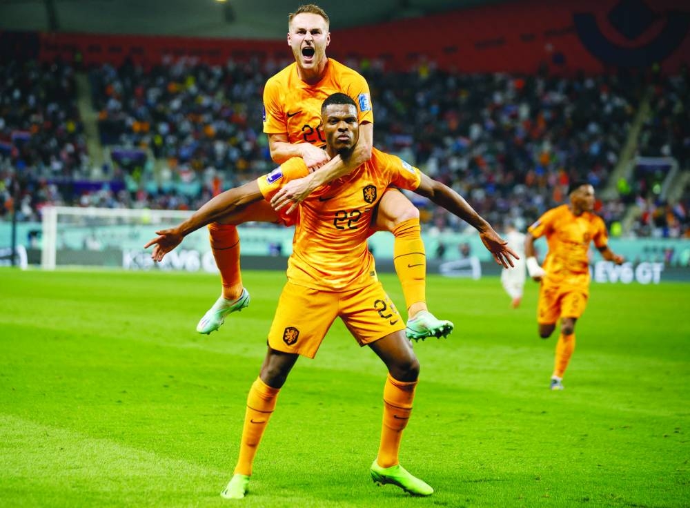 Netherlands' Denzel Dumfries celebrates scoring their third goal with Teun Koopmeiners against the United States at Khalifa International Stadium in Doha yesterday. (Reuters)