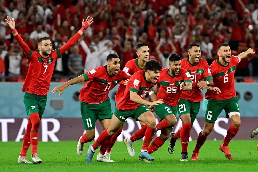 Morocco's players celebrate winning the penalty shoot-out during the Qatar 2022 World Cup round of 16 football match between Morocco and Spain at the Education City Stadium in Al-Rayyan in Doha Tuesday.