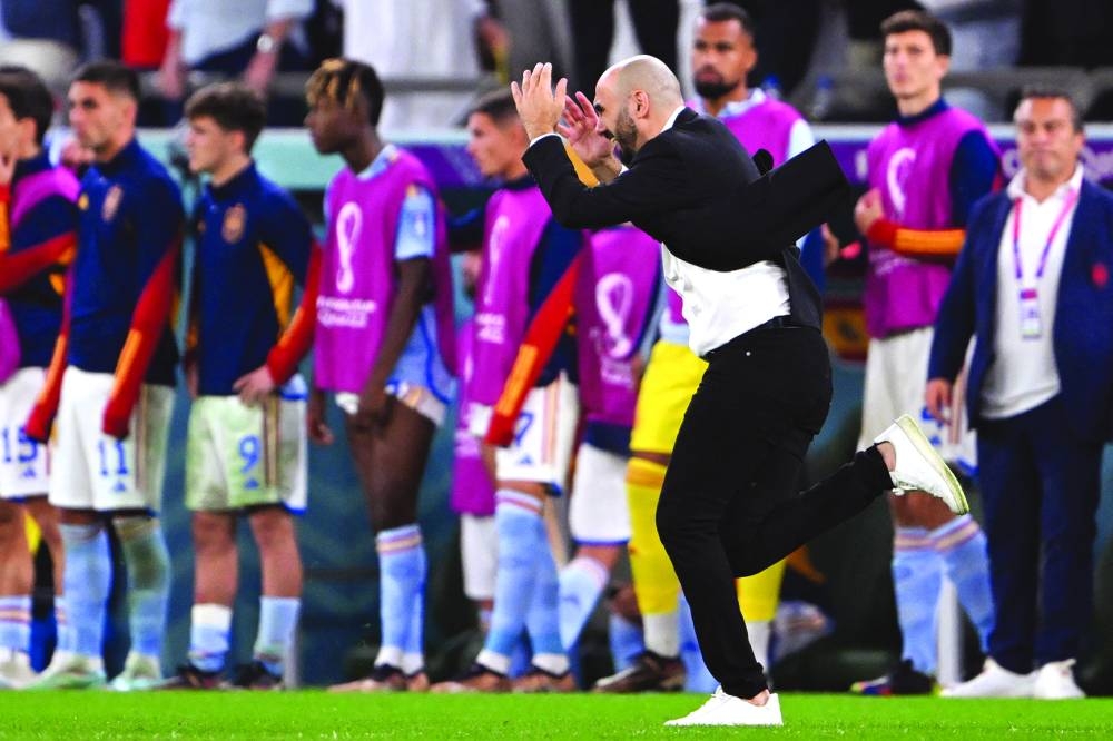 Morocco’s coach Walid Regragui (also right) celebrates after his team won the Qatar 2022 World Cup Round of 16 match against Spain at the Education City Stadium in Al Rayyan on Tuesday. (AFP)
