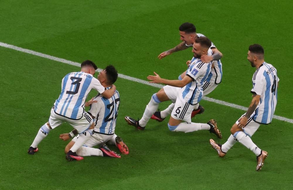 Argentina's Lautaro Martinez celebrates with teammates after scoring the winning spot kick in the penalty shootout against Netherlands at Lusail Stadium. Reuters
