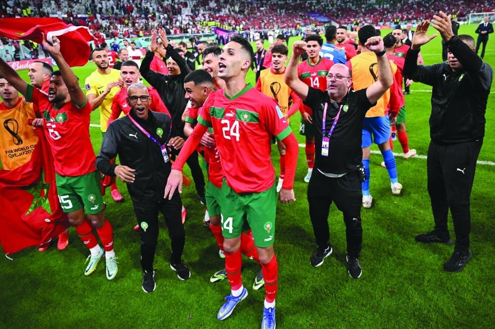 Morocco players celebrate with their supporters after they won the Qatar 2022 World Cup quarter-final football match between Morocco and Portugal at the Al-Thumama Stadium in Doha.