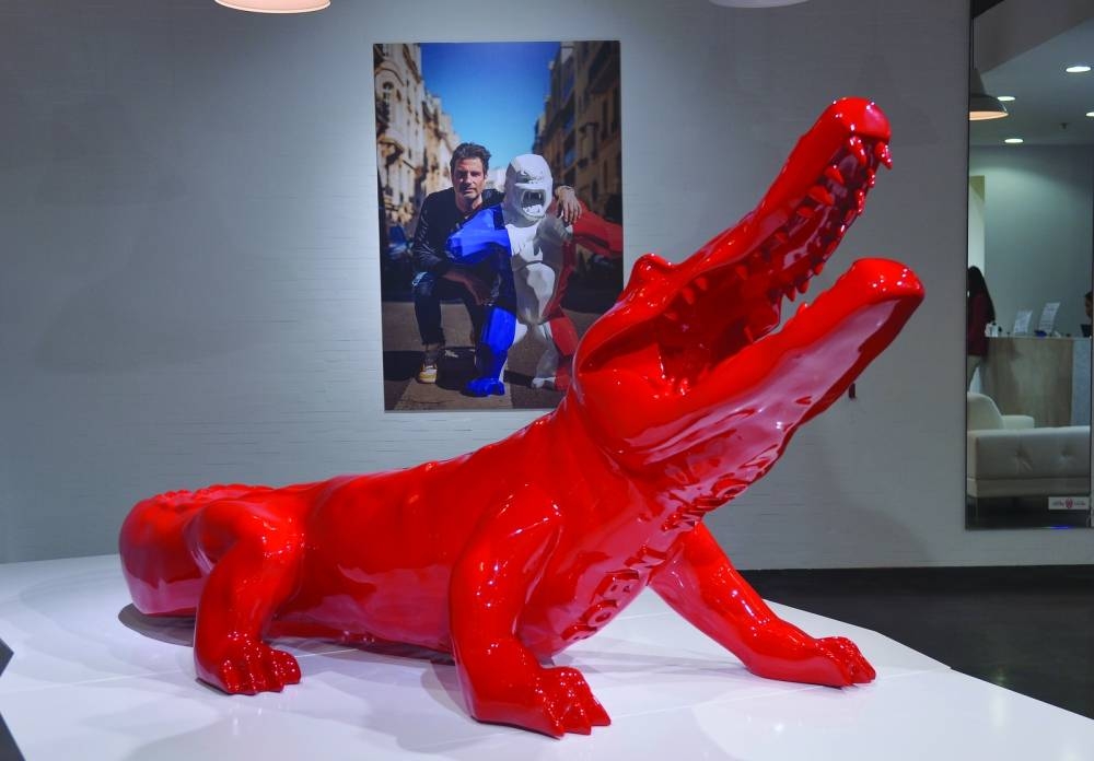 One of the artist's works includes a bright red crocodile made of resin.