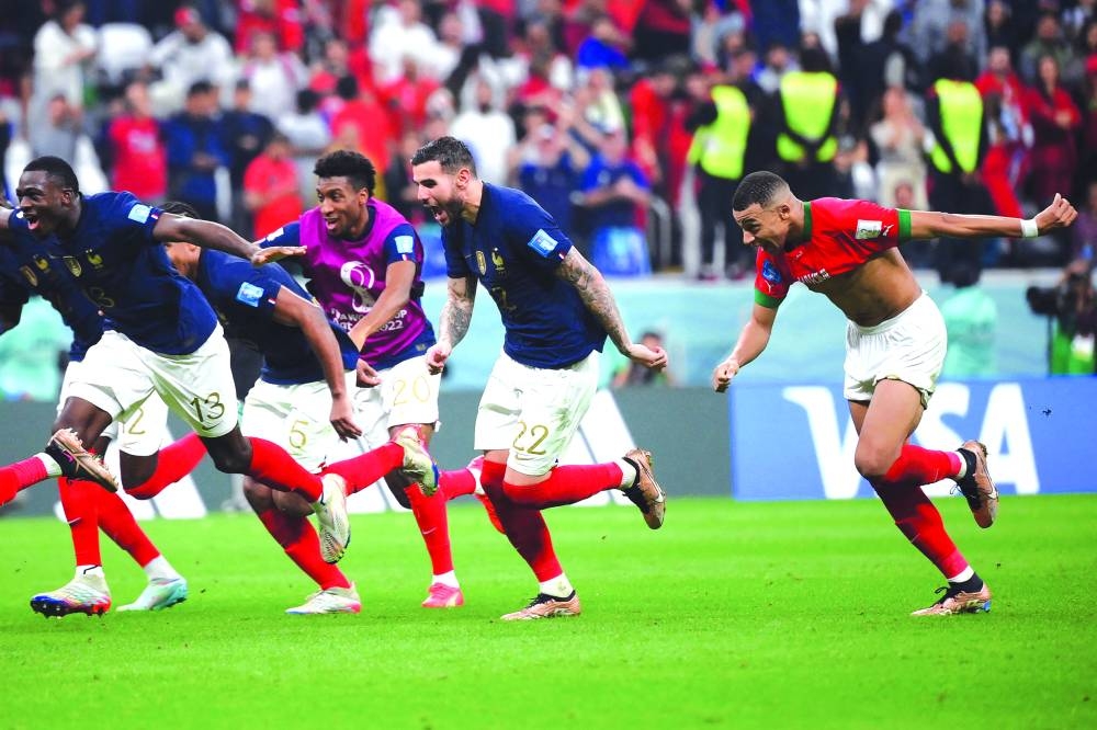 France's players celebrate their victory in the Qatar 2022 World Cup semi-final football match between France and Morocco at the Al-Bayt Stadium in Al Khor, north of Doha on December 14, 2022. (Photo by FRANCK FIFE / AFP)