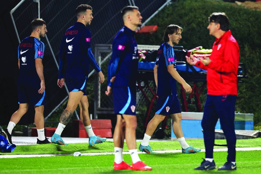 Croatia's coach Zlatko Dalic (right) speaks with his team's defender Dejan Lovren (C) as their teammates take part in a training session at Al Erssal Training Site 3 in Doha yestyerday, ahead of their third place play-off match against Morocco Saturday. (AFP)