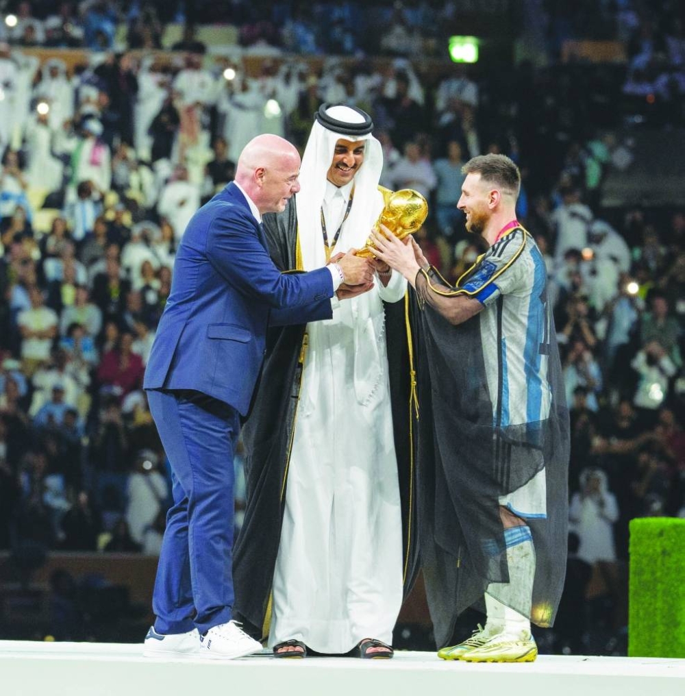 His Highness the Amir Sheikh Tamim bin Hamad al-Thani and FIFA President Gianni Infantino handing over the winner's trophy to Argentina captain Lionel Messi at Lusail Stadium. 