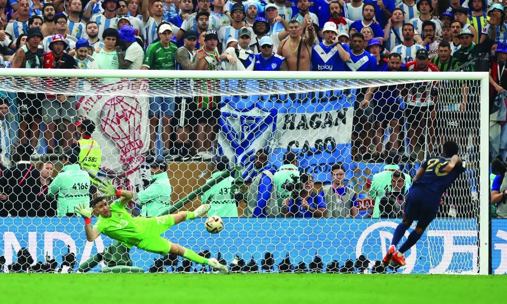 Argentina’s Emiliano Martinez saves a spot kick during the penalty shootout missed by France’s Kingsley Coman yesterday. (Reuters)