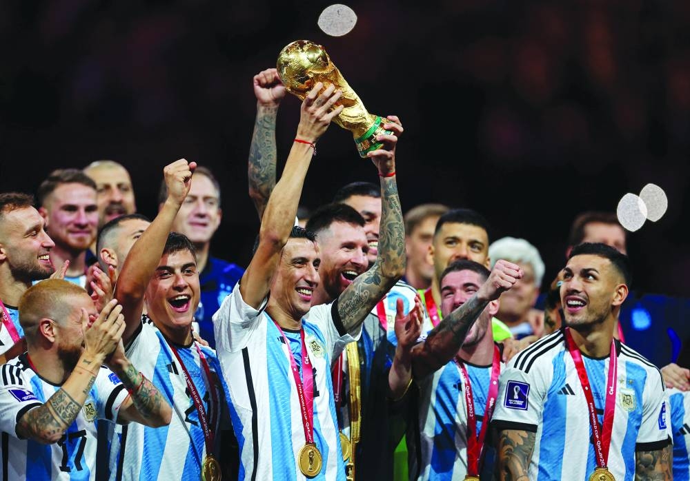 Argentina’s Angel Di Maria lifts the FIFA World Cup Trophy as he celebrates with teammates winning the Qatar 2022 World Cup at Lusail Stadium in Lusail on Sunday. (AFP)