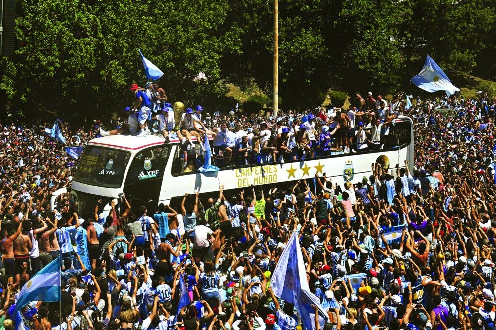 Argentina’s players celebrate on board a bus with a sign reading ‘World Champions’ with supporters as they parade through Buenos Aires downtown yesterday. (AFP)
