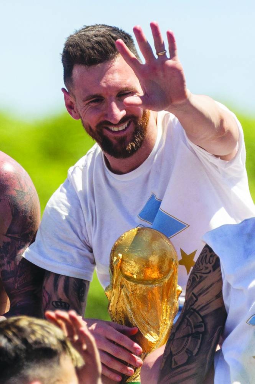 Argentine football star Lionel Messi celebrates on board a bus with a sign reading "World Champions" with supporters after winning the Qatar 2022 World Cup tournament as they tour through Buenos Aires' downtown on December 20, 2022. - Millions of ecstatic fans are expected to cheer on their heroes as Argentina's World Cup winners led by captain Lionel Messi began their open-top bus parade of the capital Buenos Aires on Tuesday following their sensational victory over France. (Photo by TOMAS CUESTA / AFP)