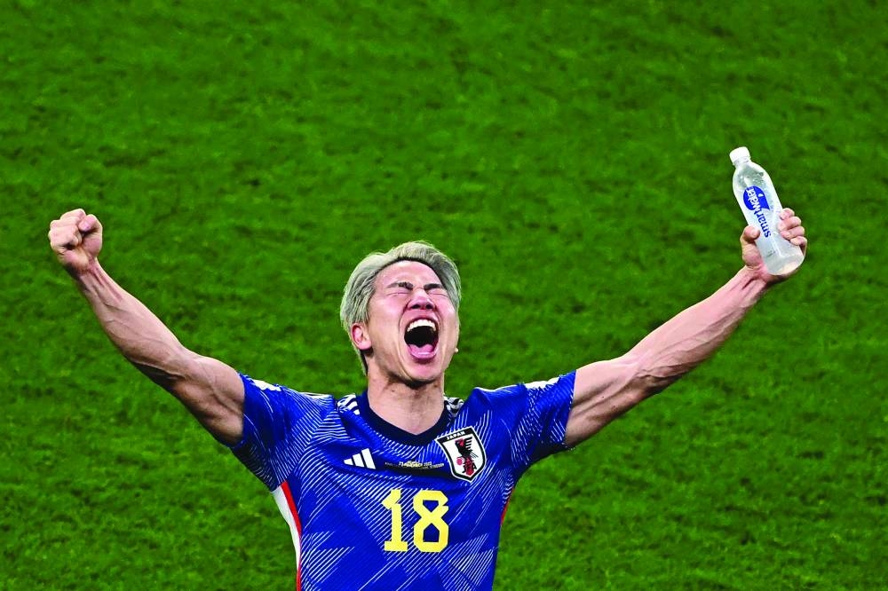TOPSHOT - Japan's forward #18 Takuma Asano celebrates his team's win in the Qatar 2022 World Cup Group E football match between Germany and Japan at the Khalifa International Stadium in Doha on November 23, 2022. (Photo by Anne-Christine POUJOULAT / AFP)