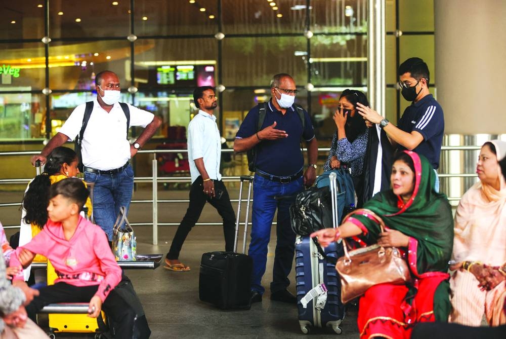 Passengers wait with their luggage at the Chhatrapati Shivaji Maharaj International Airport in Mumbai, India, yesterday. (REUTERS)