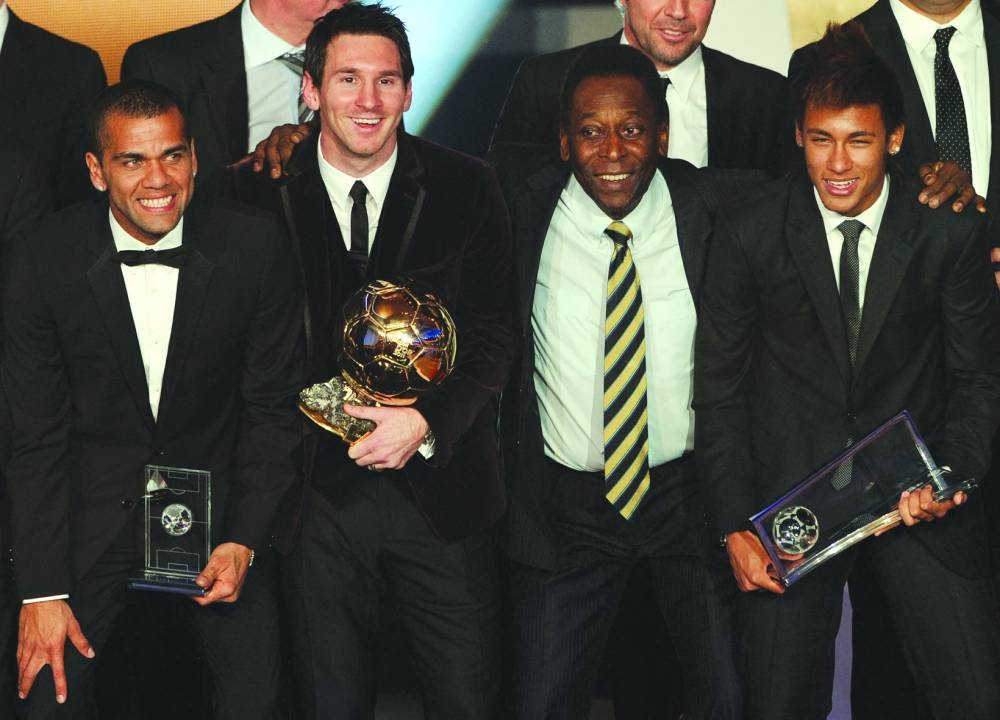 In this file photo taken on January 9, 2012, Barcelona's Argentinian forward Lionel Messi (2nd left) poses with Brazilian football legend Pele (centre), Barcelona's Brazilian Dani Alves (left) and Santos FC' Brazilian forward Neymar (right) after receiving for the third time the FIFA Ballon d'Or award at the Kongresshaus during the FIFA Ballon d'Or ceremony in Zurich, Switzerland. (AFP)
