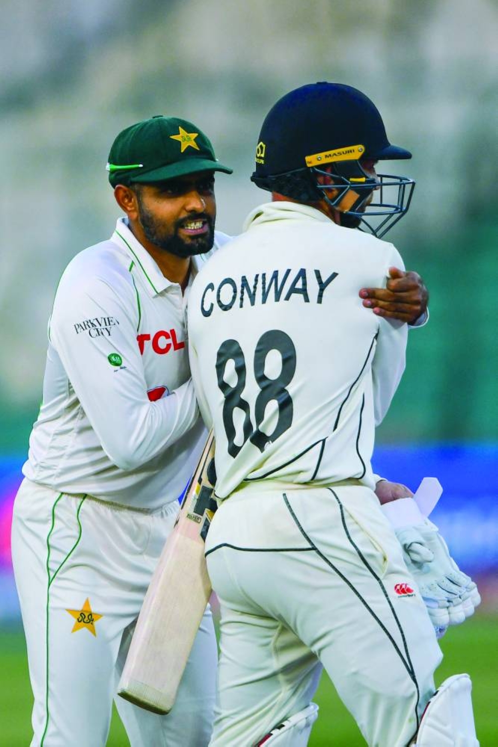 Pakistan's captain Babar Azam (left) gestures with New Zealand's Devon Conway at the end of the fifth and final day of the first Test at the National Stadium in Karachi yesterday. (AFP)