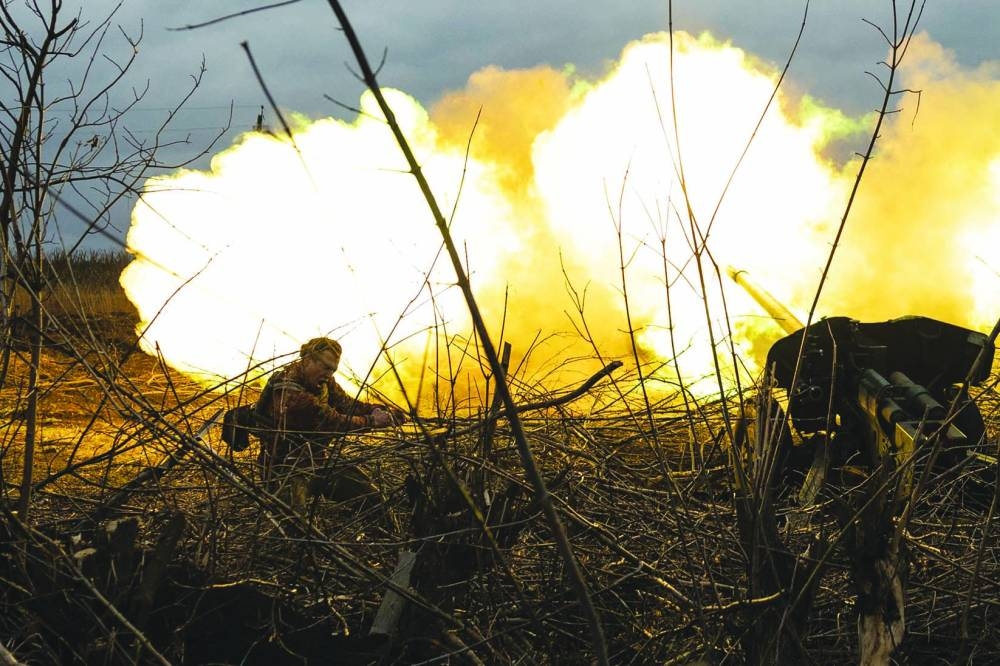 A serviceman of a Ukrainian artillery unit reacts as he fires towards Russian positions on the outskirts of Bakhmut, eastern Ukraine.