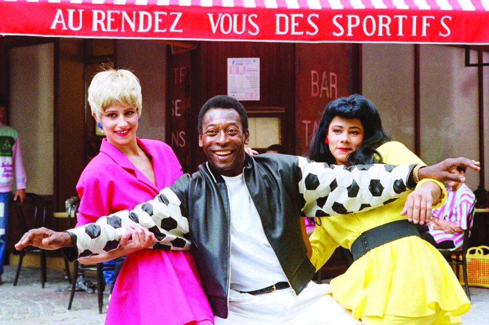 In this file photo taken on August 5, 1987 Pelé poses in Paris with two extras while he performs for an advertising movie for French Loto company. (AFP)