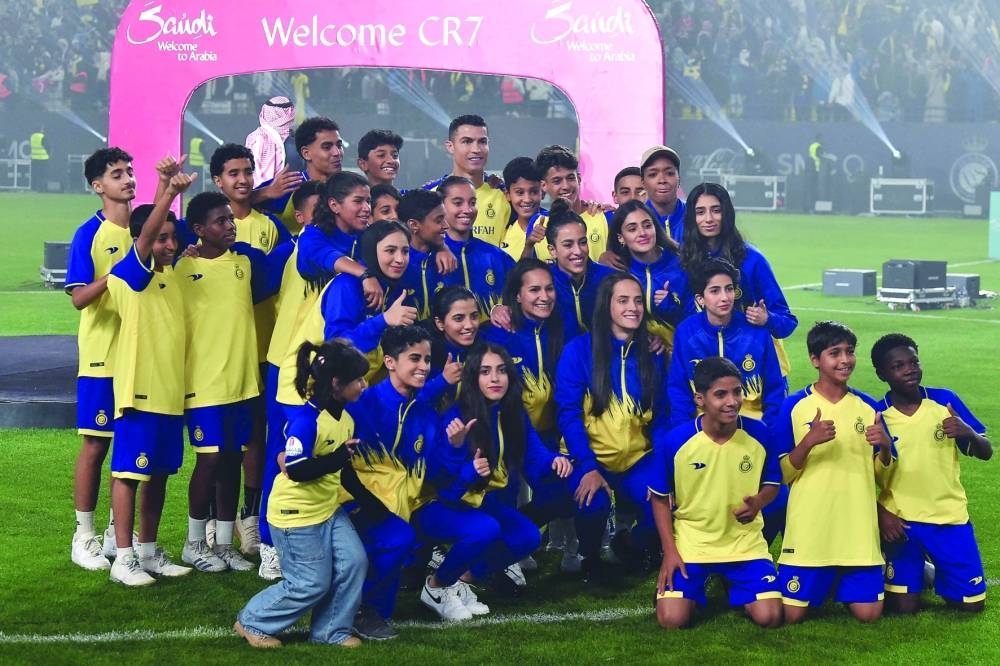 Al-Nassr's new Portuguese forward Cristiano Ronaldo poses for a picture with youths during his unveiling at the Mrsool Park Stadium in the Saudi capital Riyadh on January 3. AFP