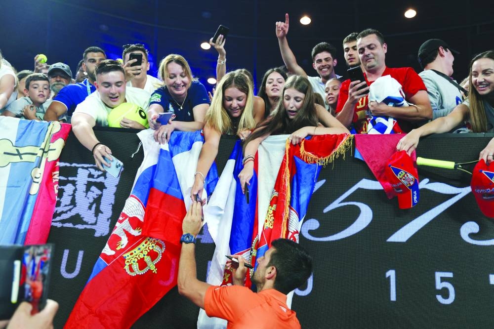 Serbia’s Novak Djokovic signs autographs for fans after the exhibition match against Australia’s Nick Kyrgios. (Reuters)