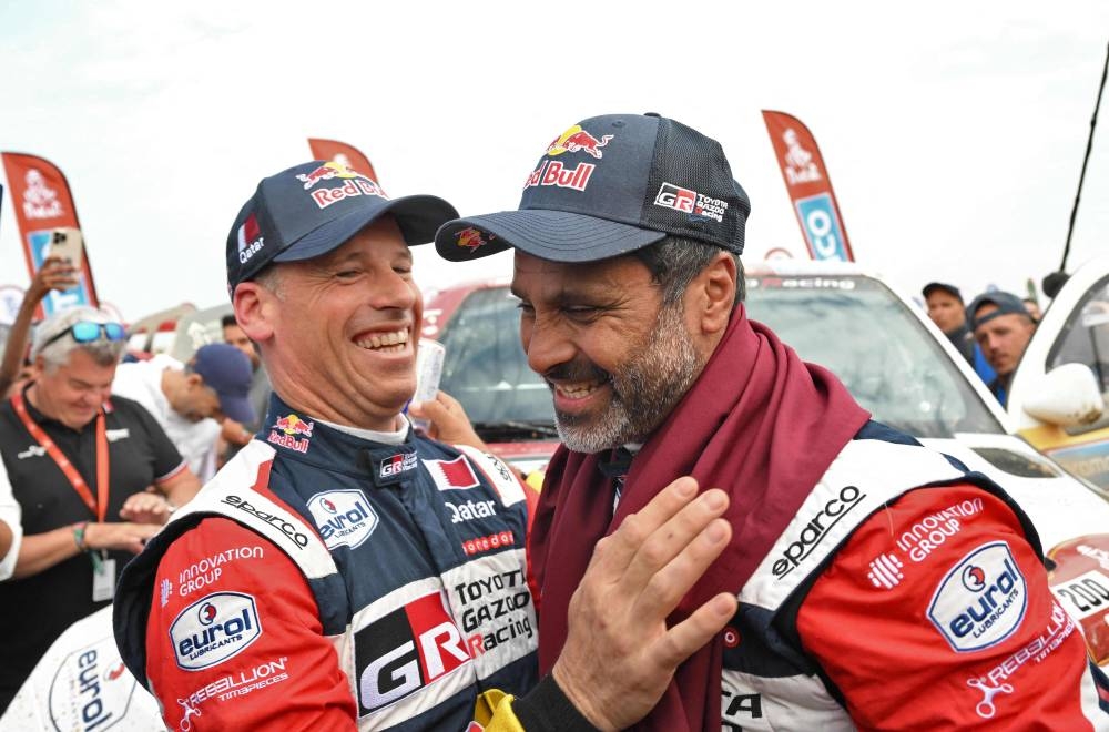 Toyota's driver Nasser Al-Attiyah of Qatar and his co-driver Mathieu Baumel of France celebrate their victory after winning the Dakar Rally 2023, at the end of the last stage between between Al-Hofuf and Dammam, Saudi Arabia, on January 15, 2023. (Photo by AFP)