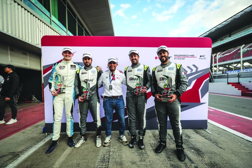 Team Thuraya drivers Abdulla Ali al-Khelaifi, Ghanim al-Ali, Ibrahim al-Abdulghani of Qatar and Germany’s Julian Hanses celebrate with Qatar Motor & Motorcycles Federation’s Executive Director Amro al-Hamad (centre) after finishing second in the Porsche 911 GT3 Cup 992 AM class at the 24H Dubai endurance race on Sunday.