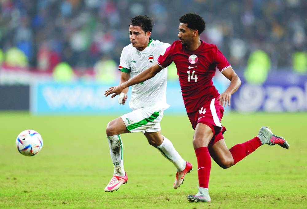 Qatar’s Homam Ahmed (right) vies for the ball with Iraq’s Ibrahim Bayesh. (Reuters)