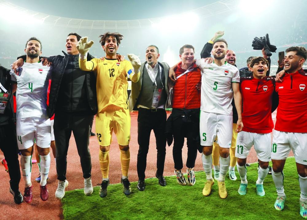 Iraq coach Casas (centre) celebrates with his players after their win over Qatar in the semi-final of the Arabian Gulf Cup at the Basra International Stadium yesterday. (Reuters)