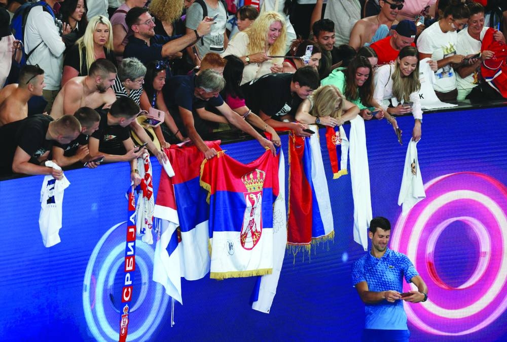 Serbia’s Novak Djokovic poses for a selfie with fans after winning his first-round match against Spain’s Roberto Carballes Baena at Melbourne Park in Australia yesterday. (Reuters)