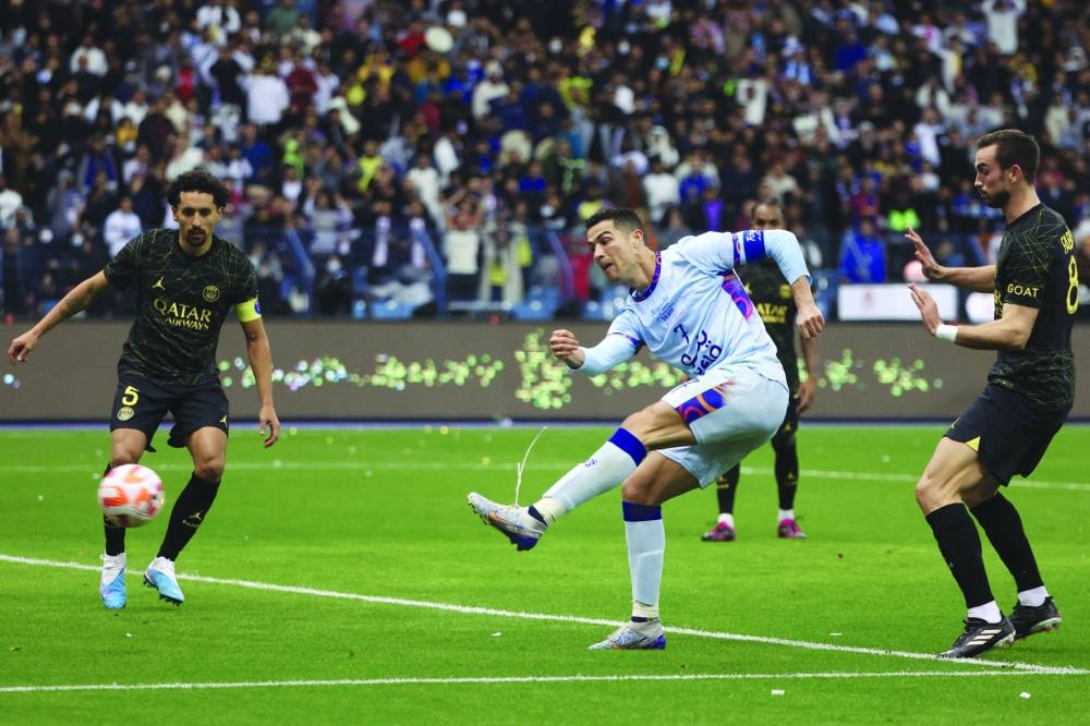 Riyadh All-Star's Portuguese forward Cristiano Ronaldo (C) shoots to score his team's second goal during the Riyadh Season Cup football match between the Riyadh All-Stars and Paris Saint-Germain at the King Fahd Stadium in Riyadh on January 19, 2023. (Photo by Giuseppe CACACE / AFP)