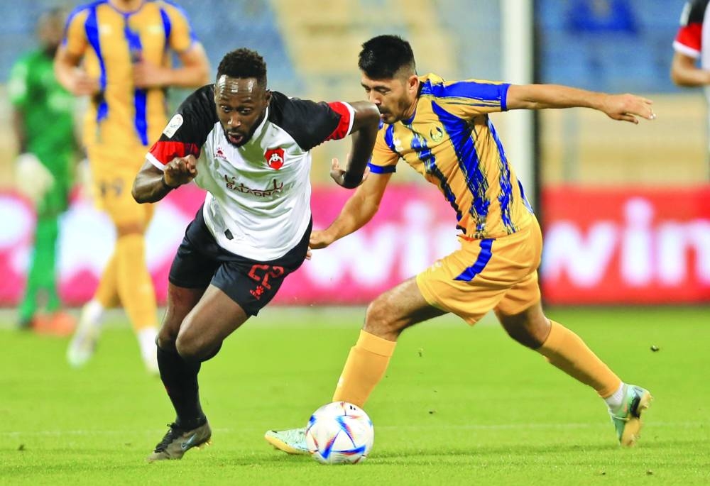 Al Rayyan's Yohan Boli (left) vies for the ball with Al Gharafa's Islom Tukhtakhujaev on Tuesday.