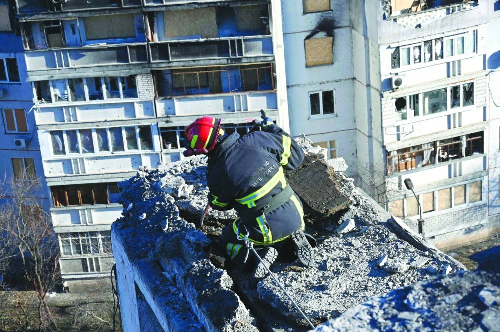 A man removes debris from a residential building during renovations of an apartment block, partially destroyed by shelling, in the outskirts of Kharkiv, amid Russian invasion of Ukraine.