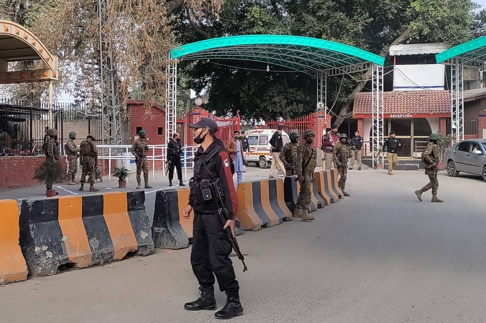 Security personnel stand guard outside the police headquarters after a blast in Peshawar on January 30, 2023. (AFP)