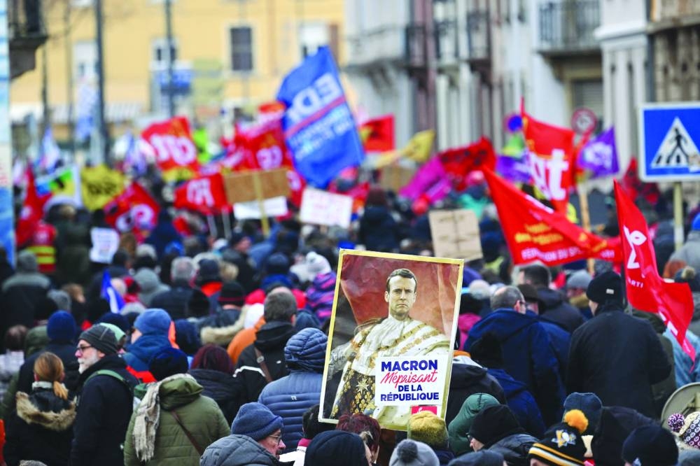 A demonstrator holds a placard reading “Macron despising of the Republique” during a demonstration on a second day of nationwide strikes and protests over the government’s proposed pension reform, in Mulhouse, eastern France yesterday.