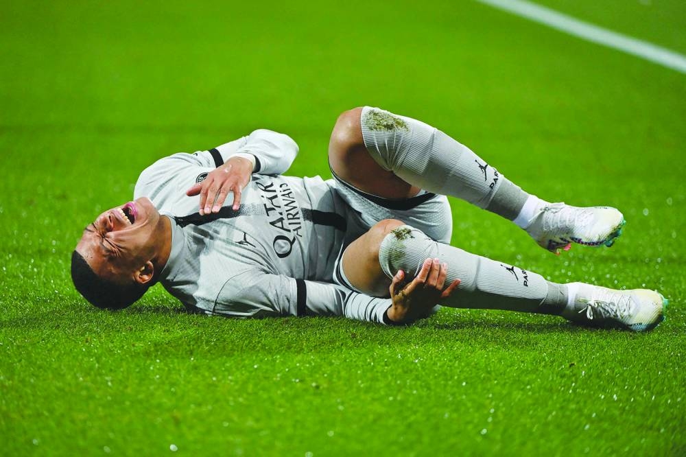 Paris Saint-Germain’s Kylian Mbappe lies on the ground after getting injured during the French Ligue 1 match against Montpellier on Wednesday. (AFP)