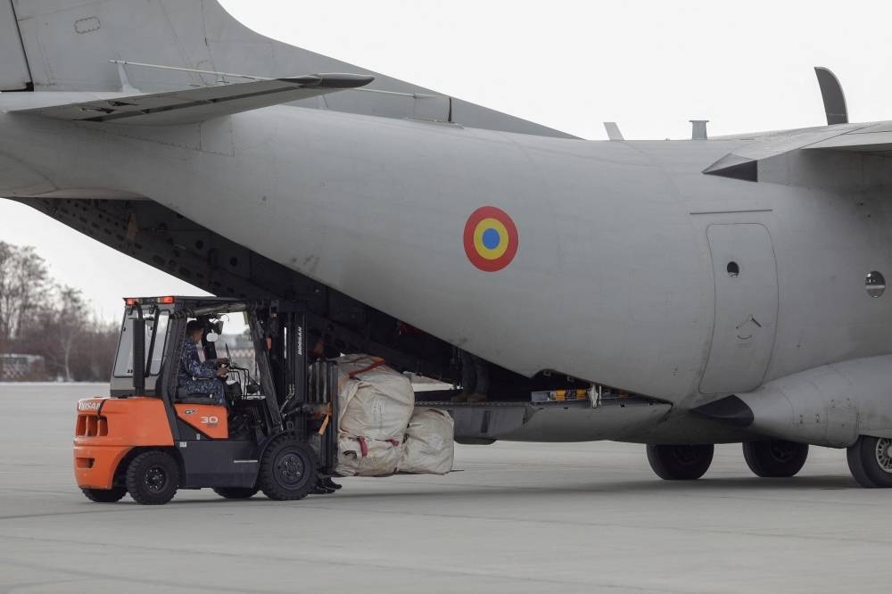 Members of a Disaster Response Unit from the Romanian Emergency Services load supplies inside a cargo plane. REUTERS