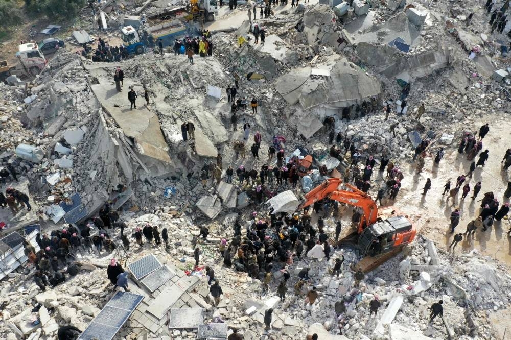  This aerial view shows residents, aided by heavy equipment, searching for victims and survivors amidst the rubble of collapsed buildings following an earthquake in the village of Besnia near the town of Harim, in Syria's rebel-held northwestern Idlib province on the border with Turkey.