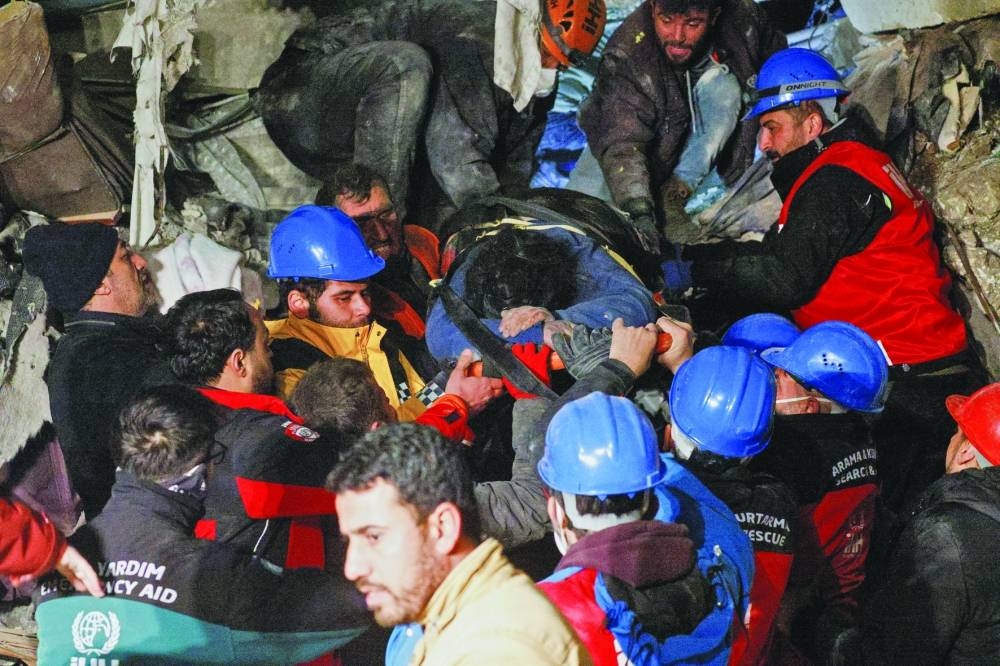 A survivor is carried on a stretcher after being rescued in Antakya, Hatay province, Turkey