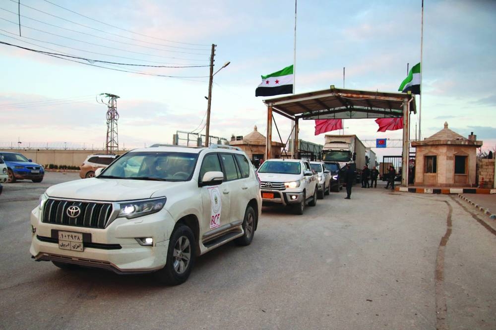 A convoy of trucks carrying humanitarian aid to earthquake victims, sent by a Kurdish charity organisation, enters Syria through the opposition-held Bab al-Salama crossing with Turkiye in the northern Aleppo province, yesterday.
