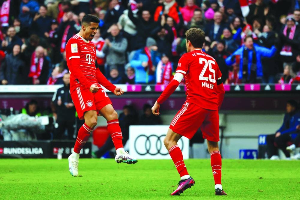Bayern Munich’s Thomas Mueller (right) celebrates scoring his team’s first goal with teammate Joao Cancelo during the Bundesliga match against VfL Bochum in Munich yesterday. (AFP) 