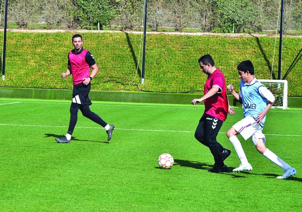 QU president Dr Hassan al-Derham during a football match with students.