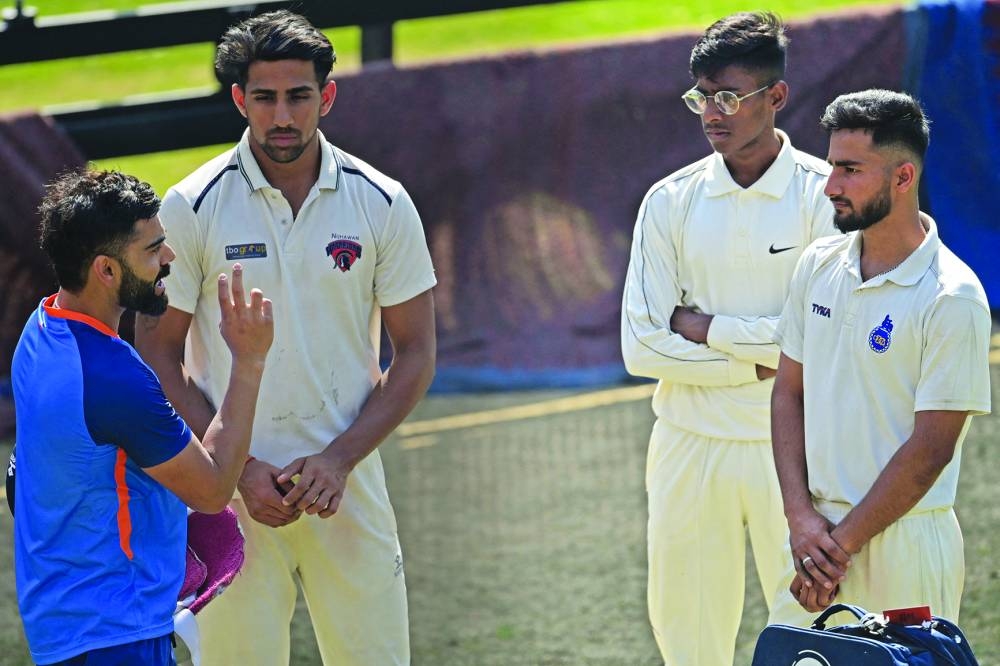 India’s Virat Kohli (left) speaks with young cricketers during a practice session at the Arun Jaitley Stadium in New Delhi ahead of their second Test against Australia starting on Friday. (AFP) 