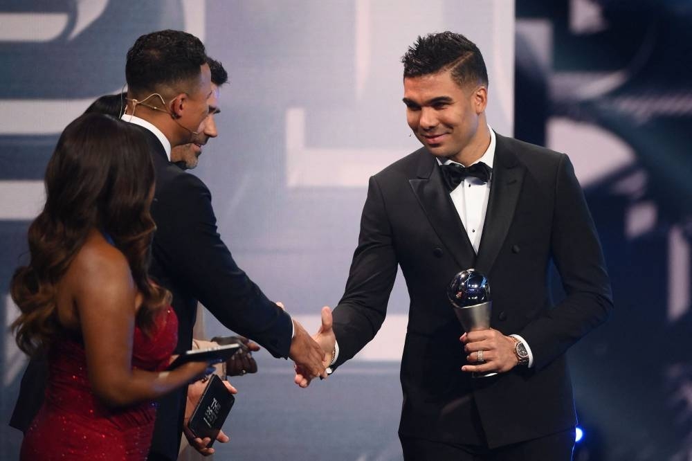 Brazil and Manchester United midfielder Casemiro (R) receives and award for the FIFA FIFPRO men's World11.