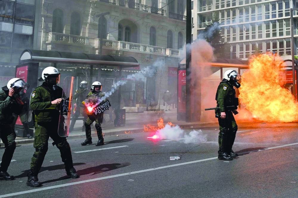 Riot police react as a petrol bomb explodes during clashes with protesters at a  demonstration in Athens yesterday following a deadly train accident late on February 28. (AFP)