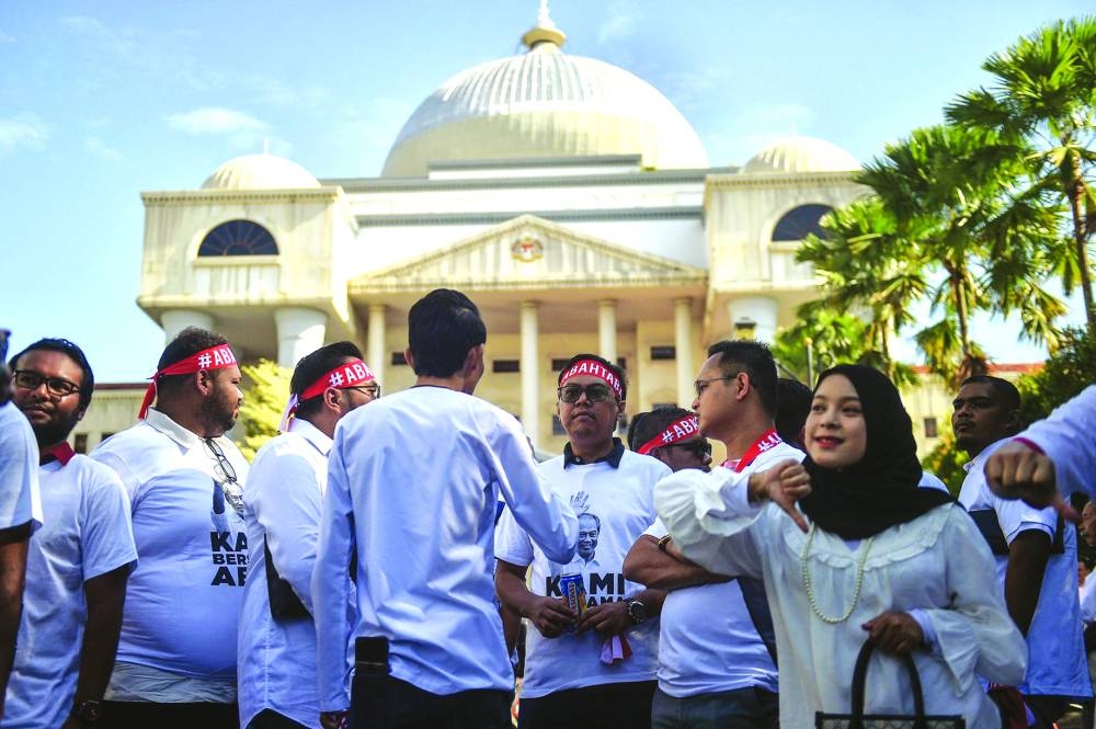 Supporters of former prime minister of Malaysia and Perikatan Nasional (PN) chairman Muhyiddin Yassin gather outside Kuala Lumpur High Court as he was charged with corruption in Kuala Lumpur  on Friday.