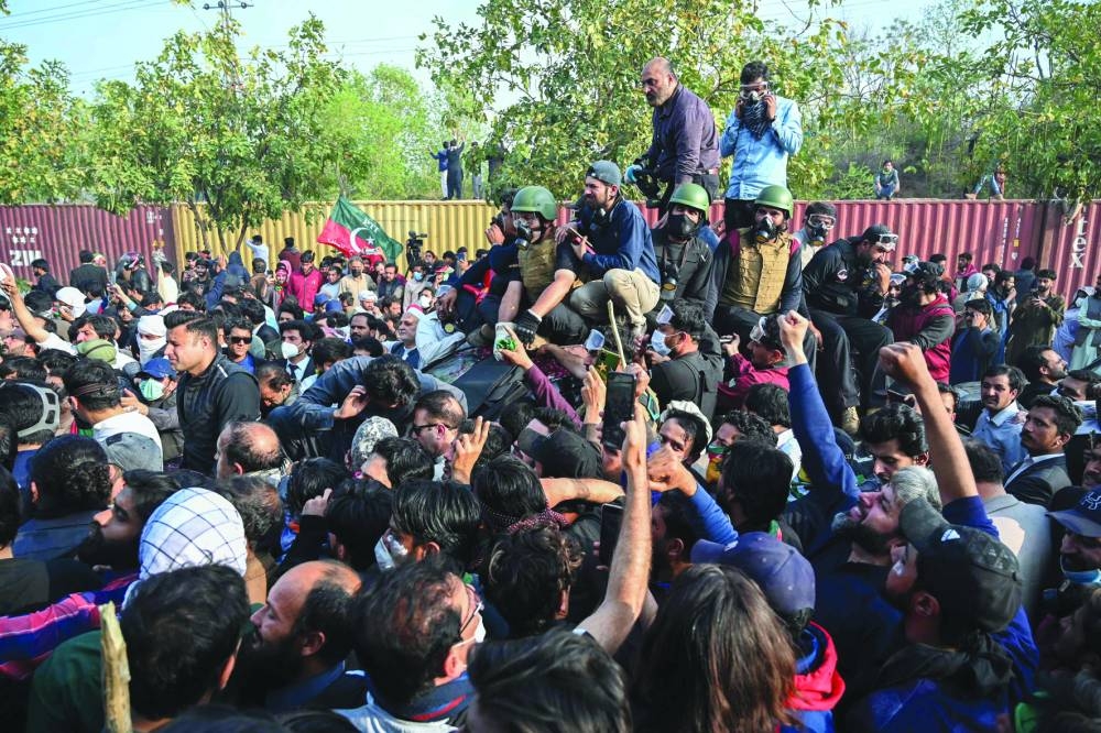 Supporters of former prime minister Imran Khan sit atop his vehicle outside a court in Islamabad.